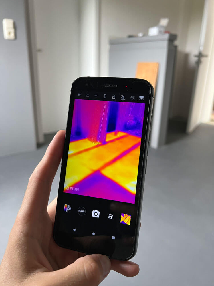 Foto eines Wärmebildes auf einem Smartphone zeigt die Leistung der versteckten Infrarot- Flächenheizung im Boden